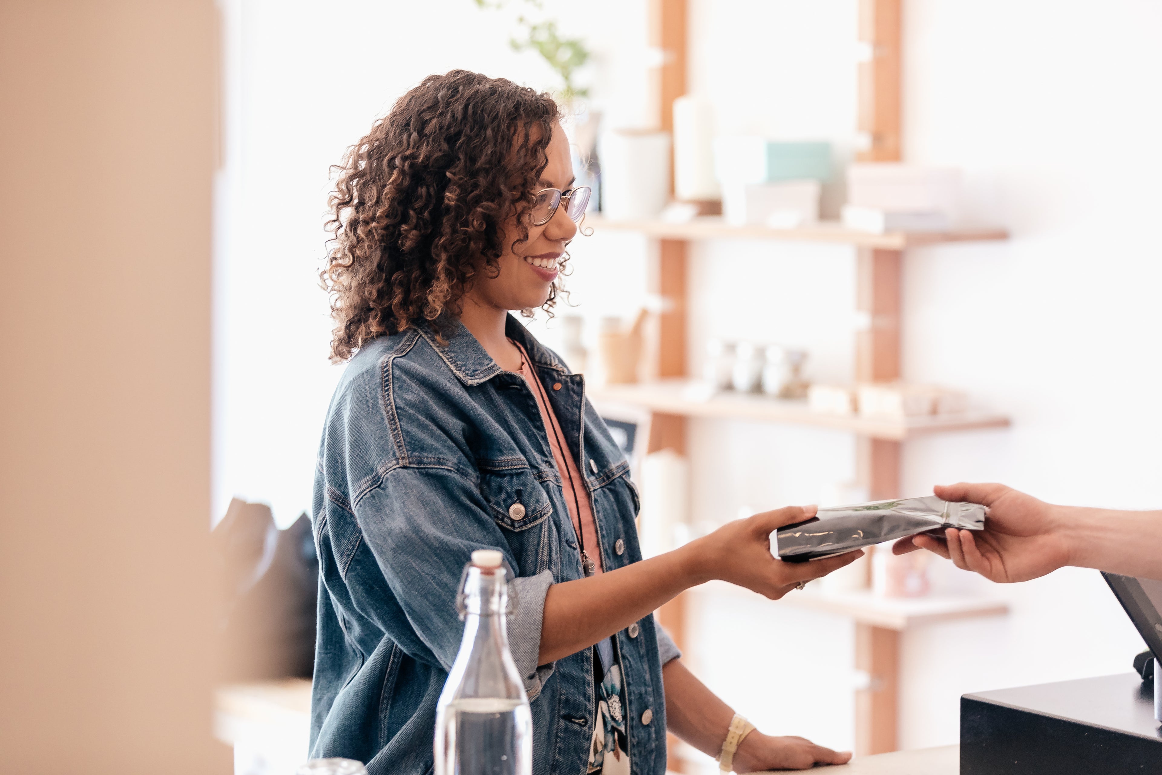 Female customer with a bright smile purchasing coffee.